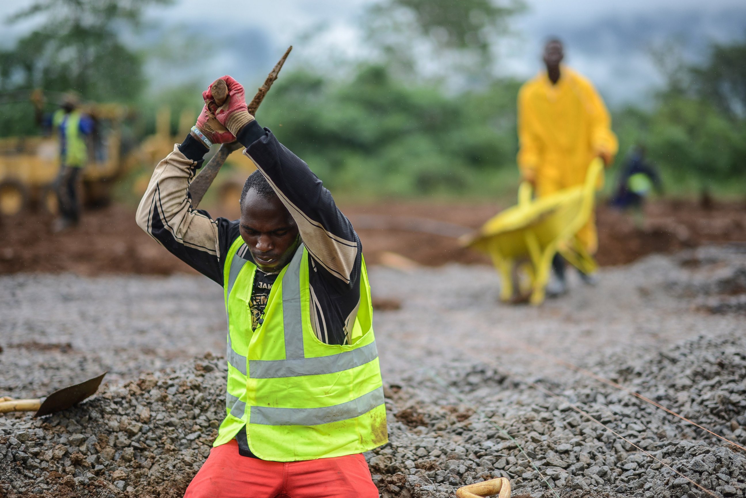 PHOTO: A worker of the International Committee of the Red Cross digs a hole with a pickaxe during the construction a brand new health center in Kenema, Sierra Leone on Aug. 25, 2014. 