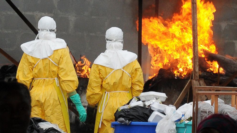 Health care workers wearing full body suits burn infected items at the ELWA Hospital in Monrovia on Aug. 30, 2014. 