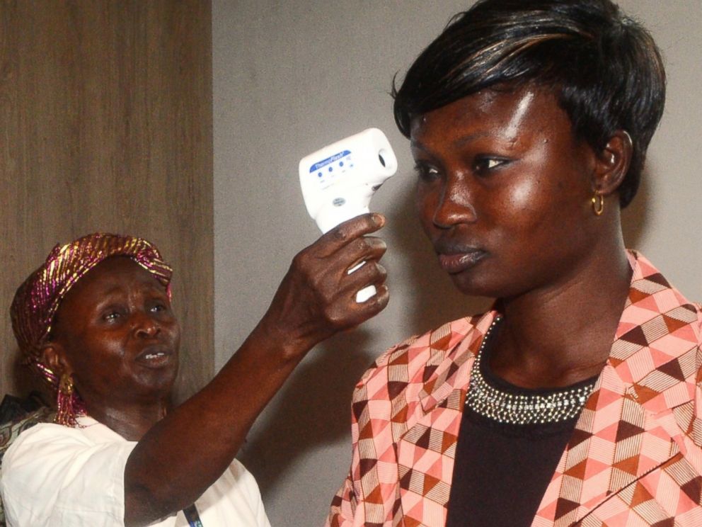 PHOTO: An employee of the sanitary control of Conakry International Airport screens a passenger before she leaves the country on April 10, 2014 in Conakry, Republic of Guinea.