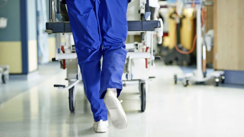 A doctor walks down a hospital hallway.