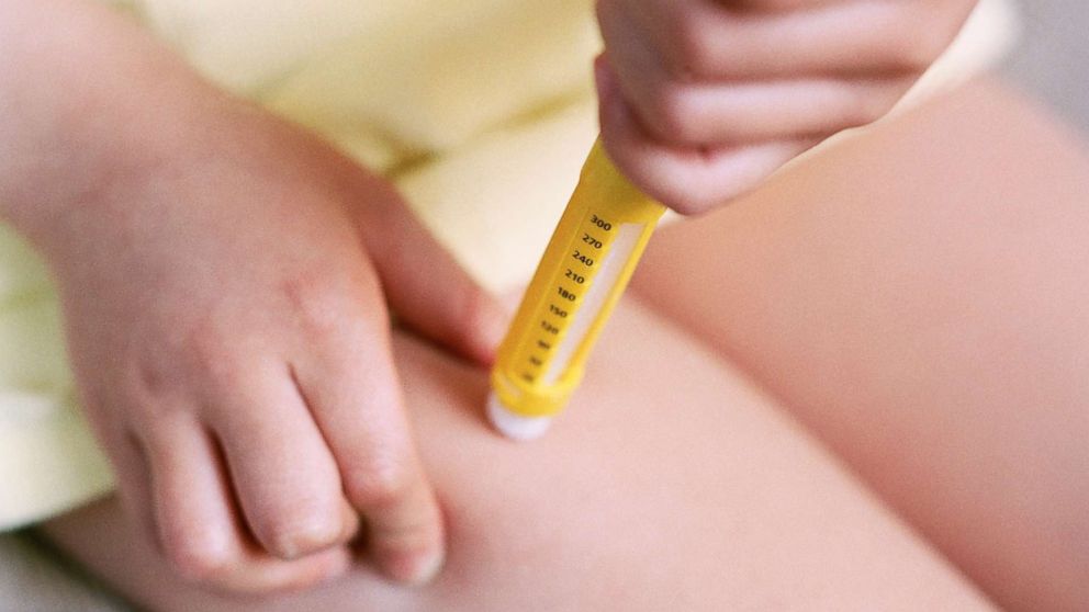 PHOTO: A young adult uses an epipen.