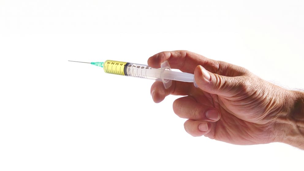 A doctor holds a flu vaccination syringe in this undated file photo.