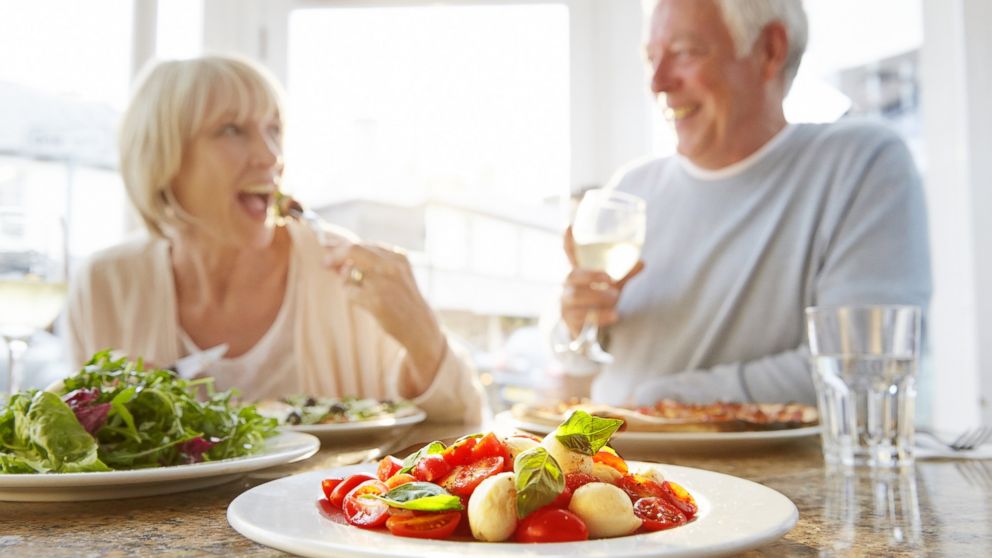 In this stock image, a couple is pictured eating healthier food options. 