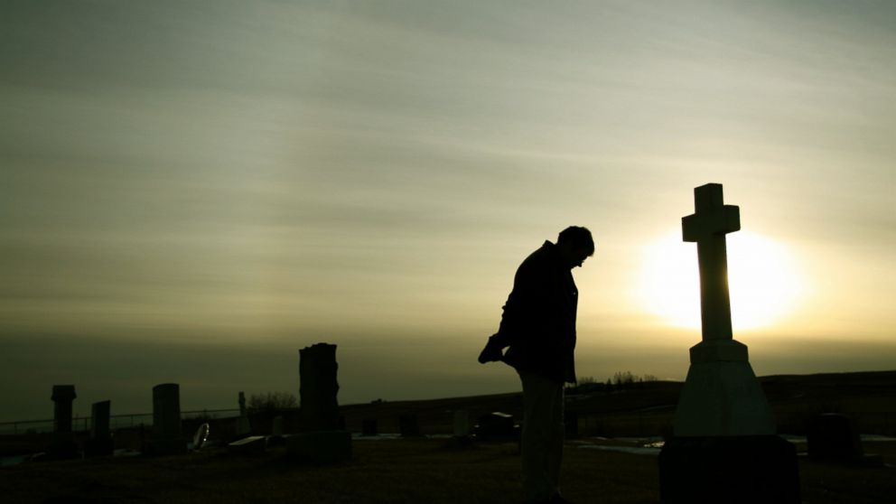 Man Mourning at Graveyard