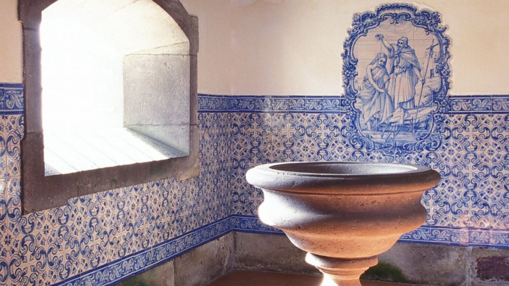 A holy water font is shown in the baptism area of a church.