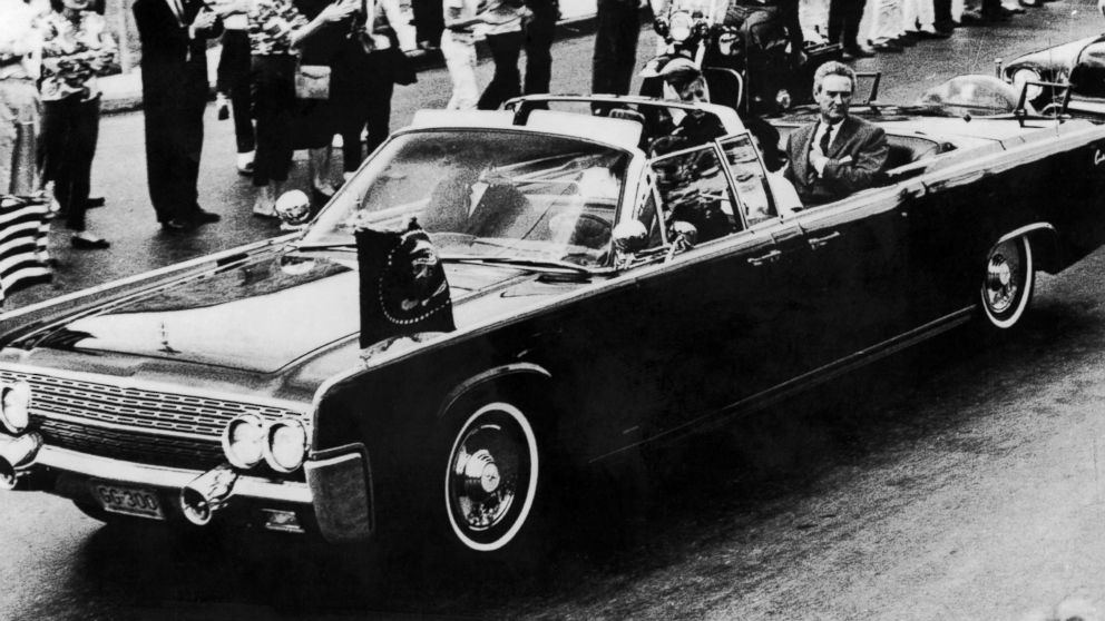 The presidential motorcade travels through Dallas a few moments before John F Kennedy was shot.