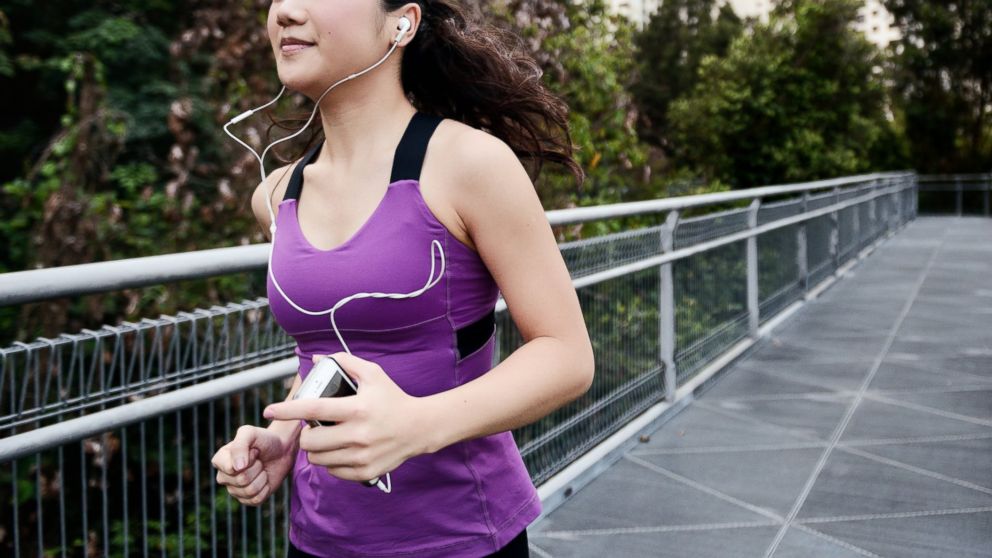 A woman holds her smart phone while running in this undated stock photo.