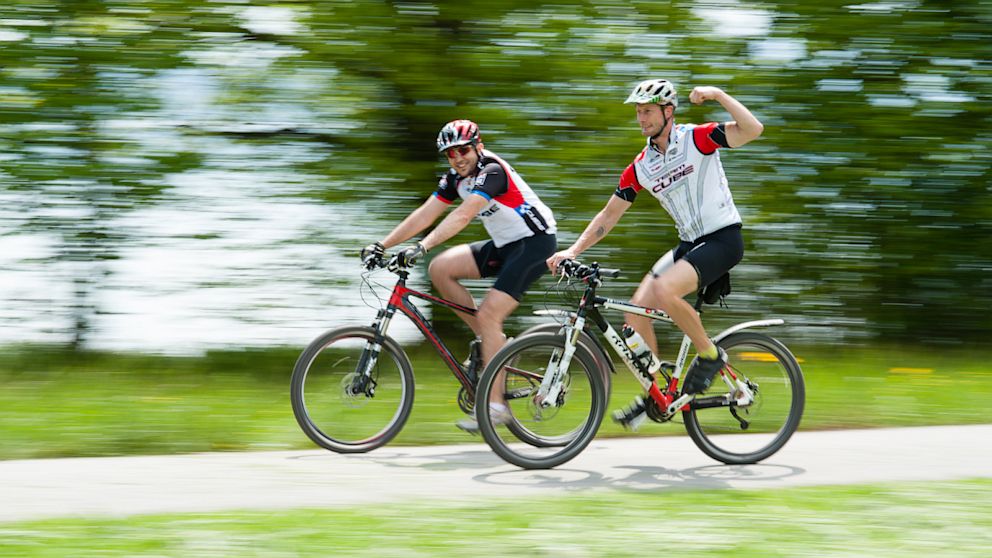 Two mountain bikers enjoy a ride on their bikes.