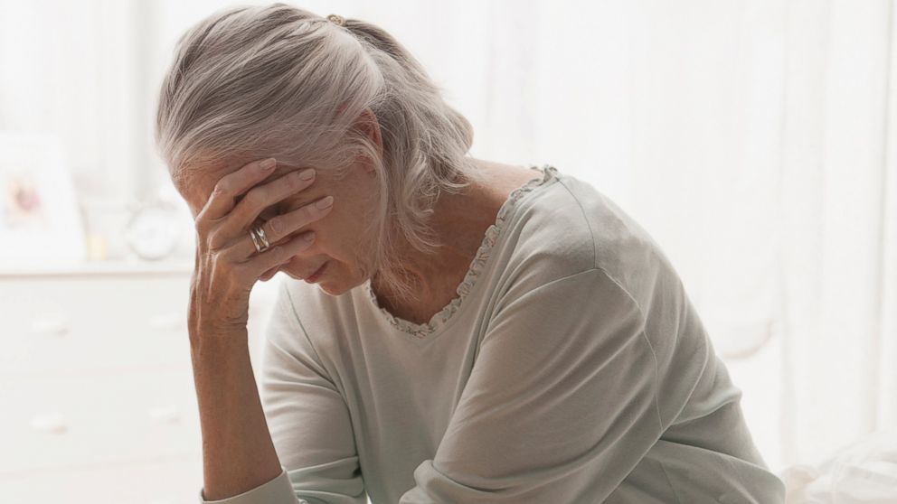 An older woman holds her head in this undated stock photo.