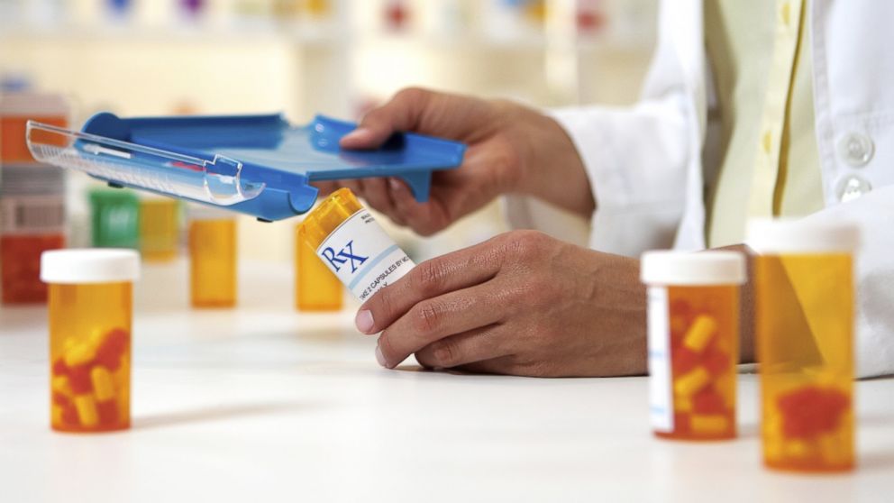 A pharmacist is pictured separating medications in this stock photo. 