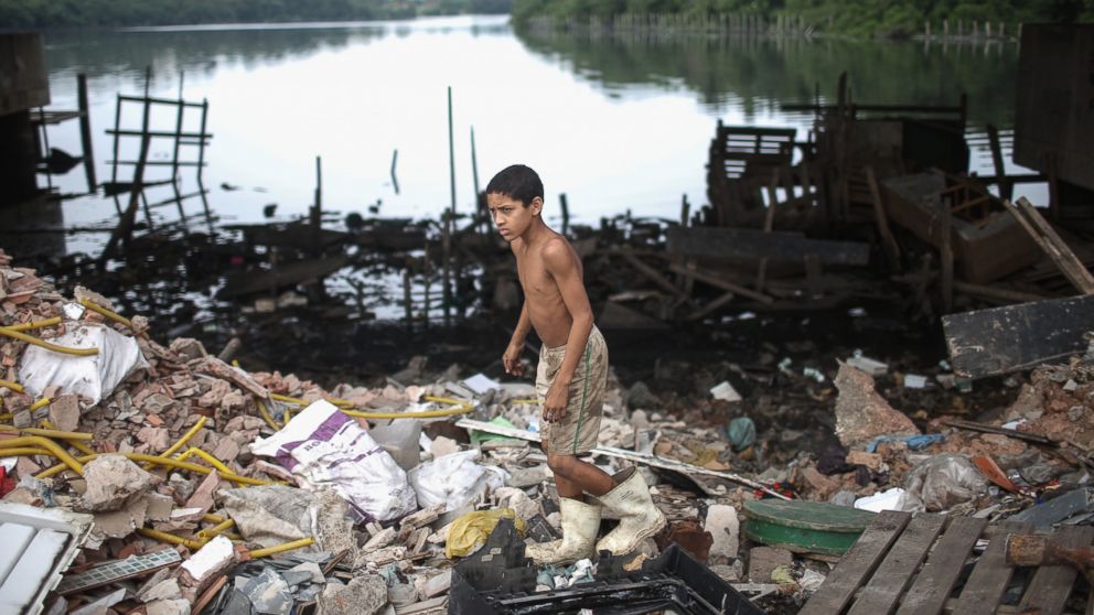 A boy looks for items to recycle along the polluted Cunha canal which flows into the notoriously polluted Guanabara Bay, site of sailing events for the Rio 2016 Olympic Games, July 29, 2015, in Rio de Janeiro.