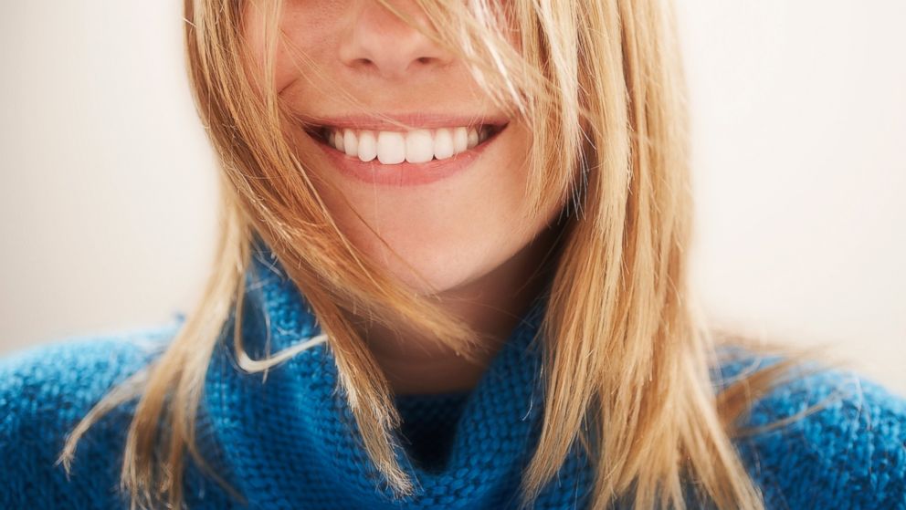 In this stock image, a young woman is pictured smiling. 