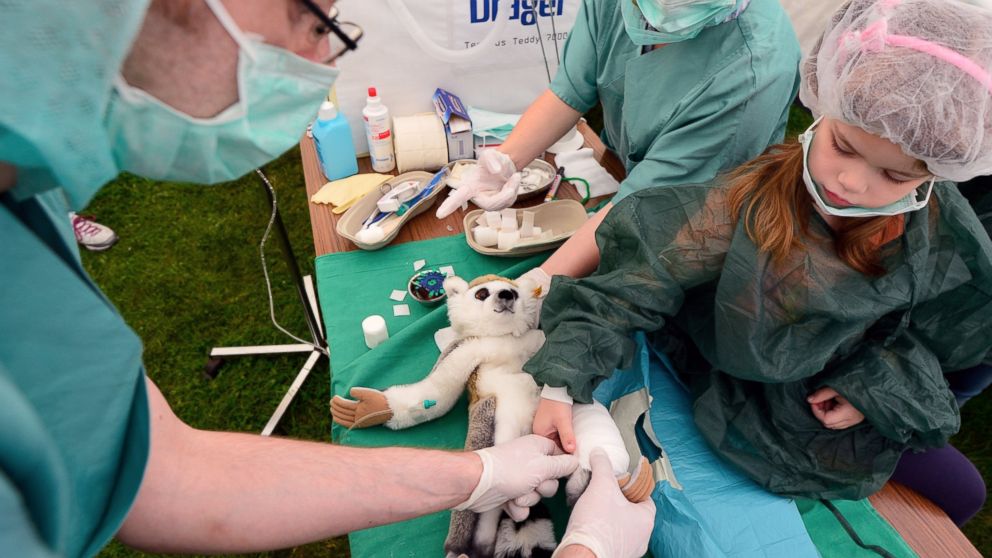 PHOTO: Cara, age 5, "operates" on a stuffed guenon at the "Teddy Clinic'' on June 4, 2014 in Giessen, Germany. 
