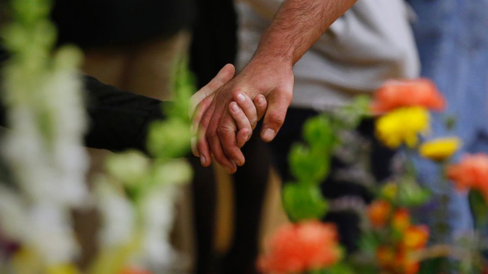 People hold hands as after a memorial service for a person who killed himself in his bedroom, in Wiscasset, Maine.  