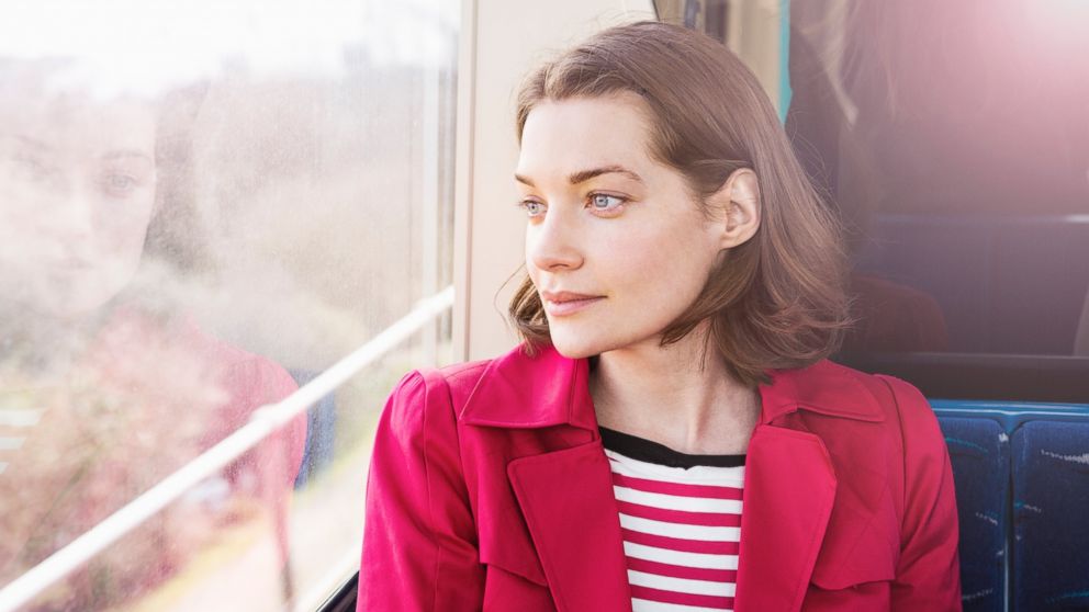 In this stock image, a woman is pictured sitting on a train.