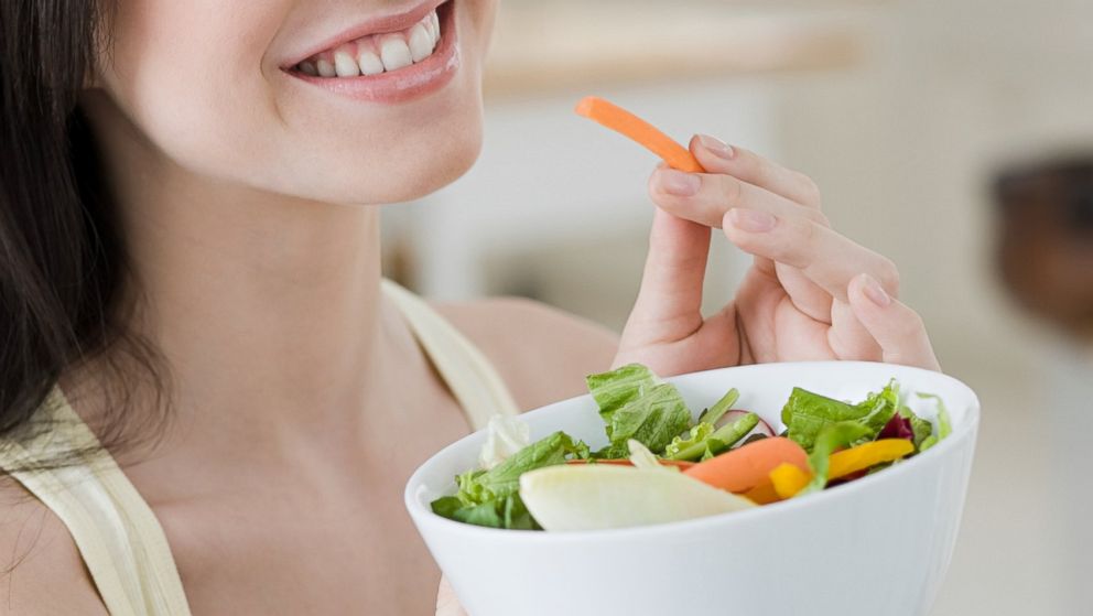 In this stock image, a woman is pictured eating a salad. 