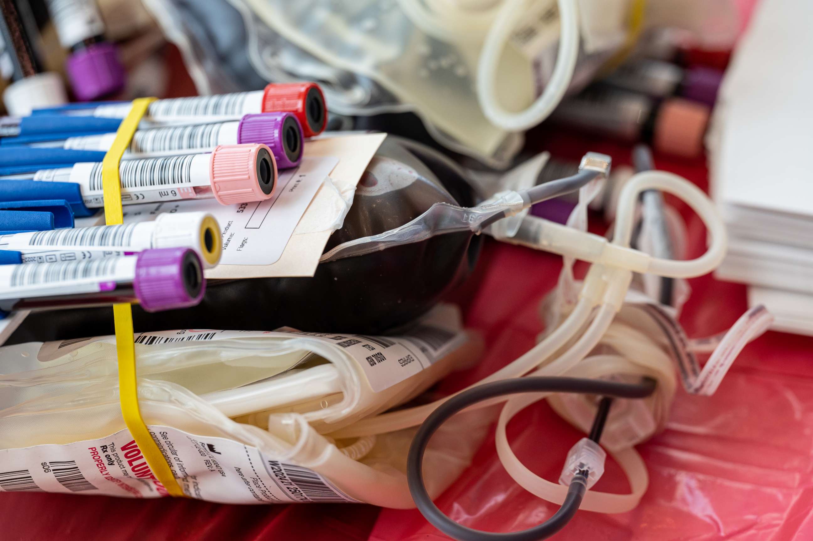 A bag of blood is seen sitting on a table at a Red Cross blood drive. 