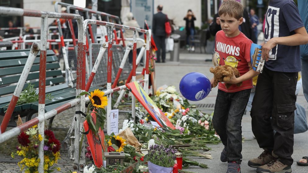 Fabian, 6, arrives with his brother and father to lay a teddy bear among flowers left by mourners outside the French Embassy the day after the terror attack in Nice that left at least 84 people dead, July 15, 2016 in Berlin, Germany. 