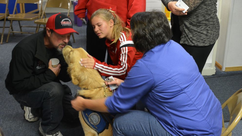 PHOTO: Residents hugged the golden retrievers at a church gathering Monday night.