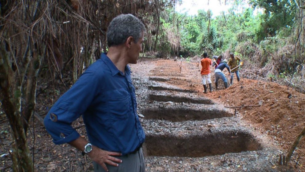 PHOTO: Dr. Besser looks on as workers dig graves outside an Ebola clinic in Liberia.