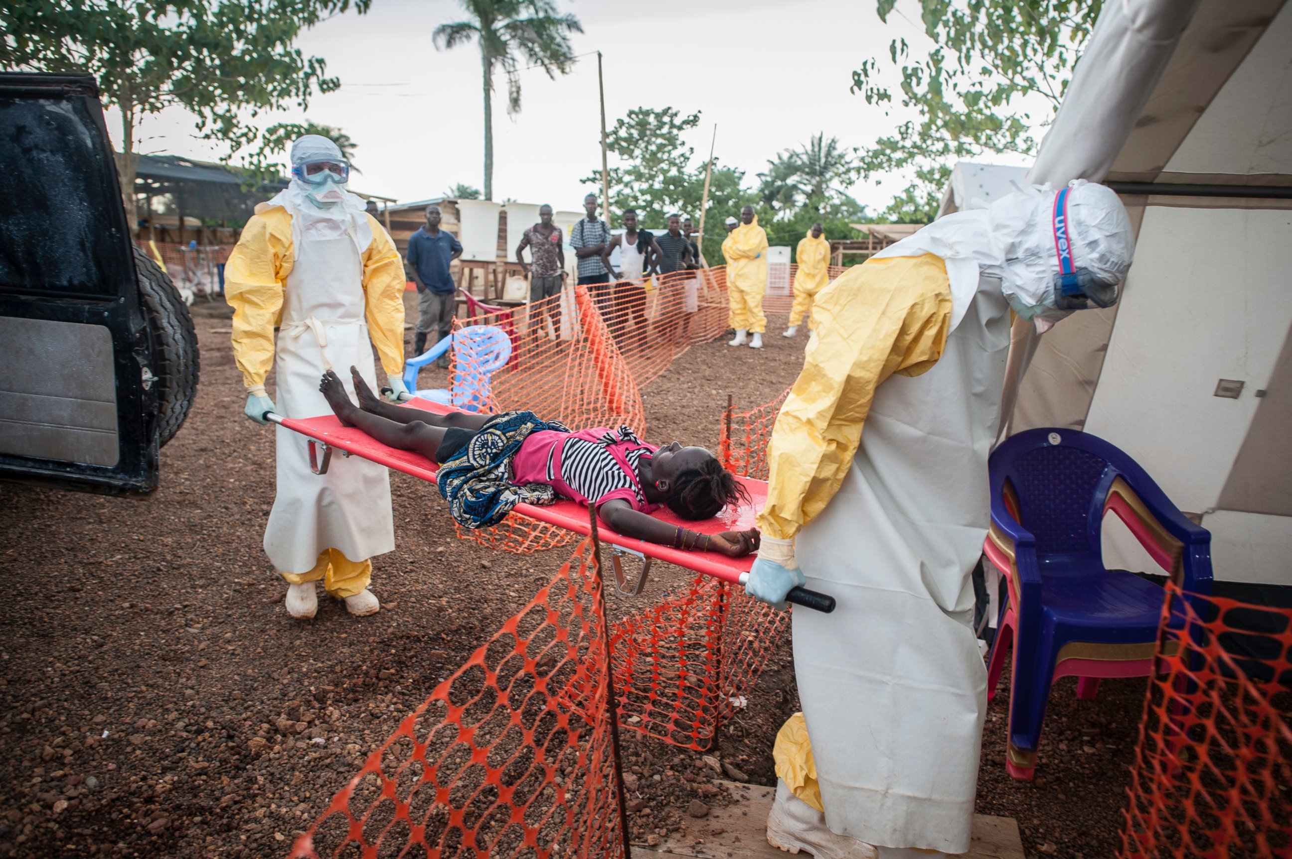 PHOTO: Two medical staff are bringing a weak patient who has been in contact with people infected with Ebola to the admission at MSF Ebola Treatment Centre in Kailahun, Sierra Leone.