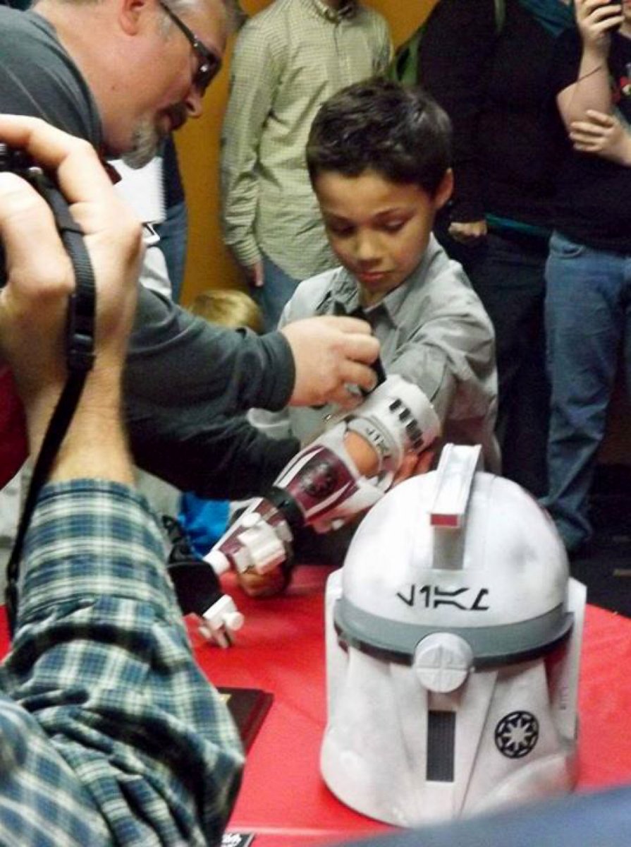 PHOTO: Liam Porter receives a Clone Trooper prosthetic arm from the charity group, E-Nable