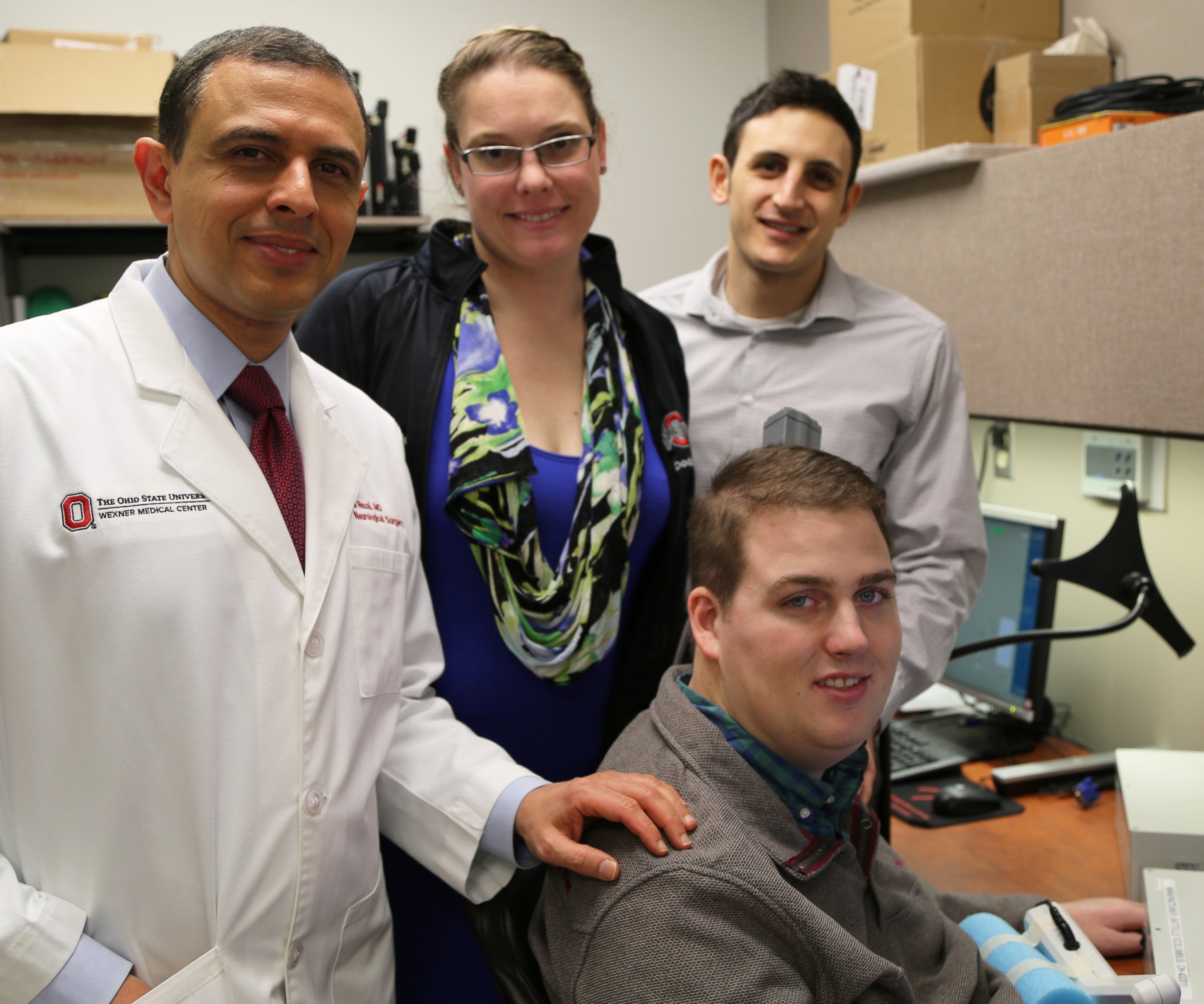 PHOTO: Patient Ian Burkhart, seated, poses with members of the research team. from left, Dr. Ali Rezai and Dr. Marcie Bockbrader of The Ohio State University Wexner Medical Center and Nick Annetta of Battelle during a neural bypass training session.