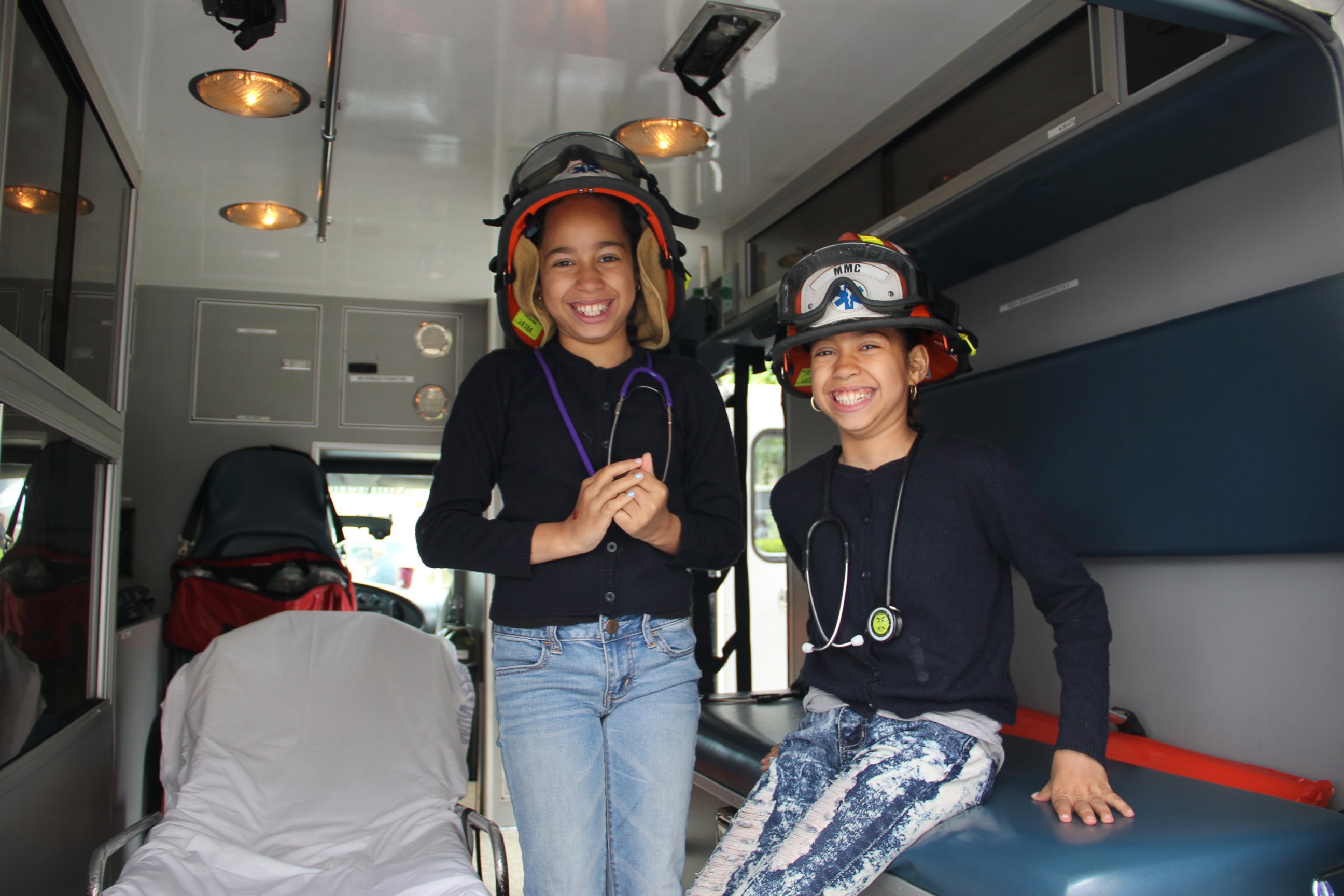 PHOTO: Ten-year-old twins Jayleen and Jayda check out an ambulance and try on EMT gear.