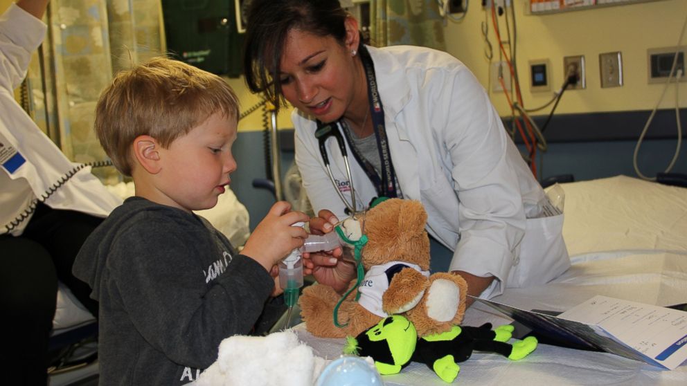 Three-year-old Sean Polidoro administers oxygen to his sick teddy bear.