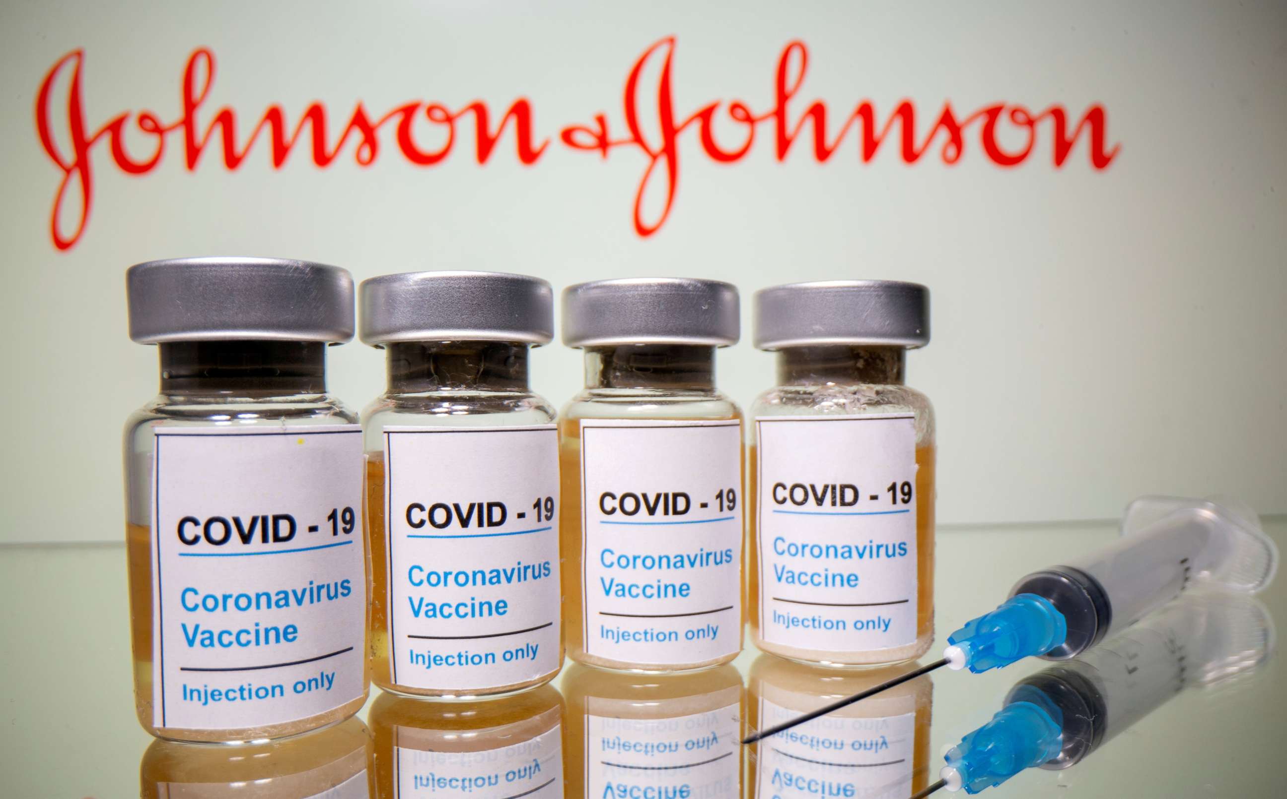 FILE PHOTO: Vials with a sticker reading, "COVID-19 / Coronavirus vaccine / Injection only" and a medical syringe are seen in front of a displayed Johnson & Johnson logo in this illustration taken October 31, 2020. 