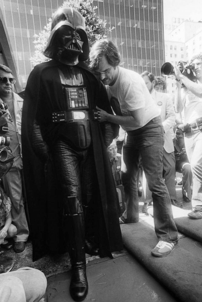 PHOTO: Lucasfilm Vice President of Advertising, Publicity, Promotion and Merchandising Charles Lippincott gives Darth Vader a hand as he adds his footprints in concrete in front of Grauman's Chinese Theater in Hollywood on August 3, 1977. 