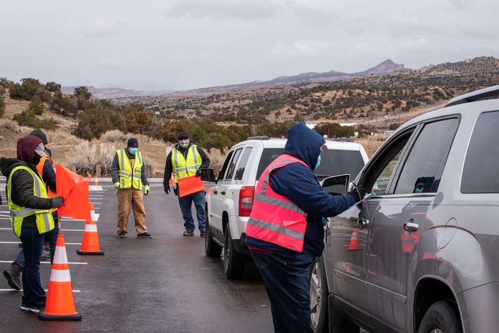 PHOTO: A healthcare worker fills out an intake form for a person in a vehicle arriving for a second dose of the Covid-19 vaccine outside the University of New Mexico's Gallup campus in Gallup, N.M., March 23, 2021.