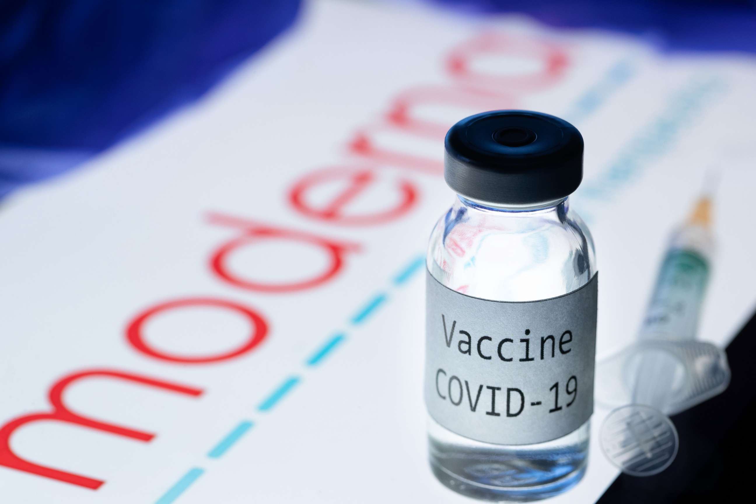 PHOTO: This picture taken on November 18, 2020 shows a syringe and a bottle reading "Vaccine Covid-19" next to the Moderna biotech company logo.