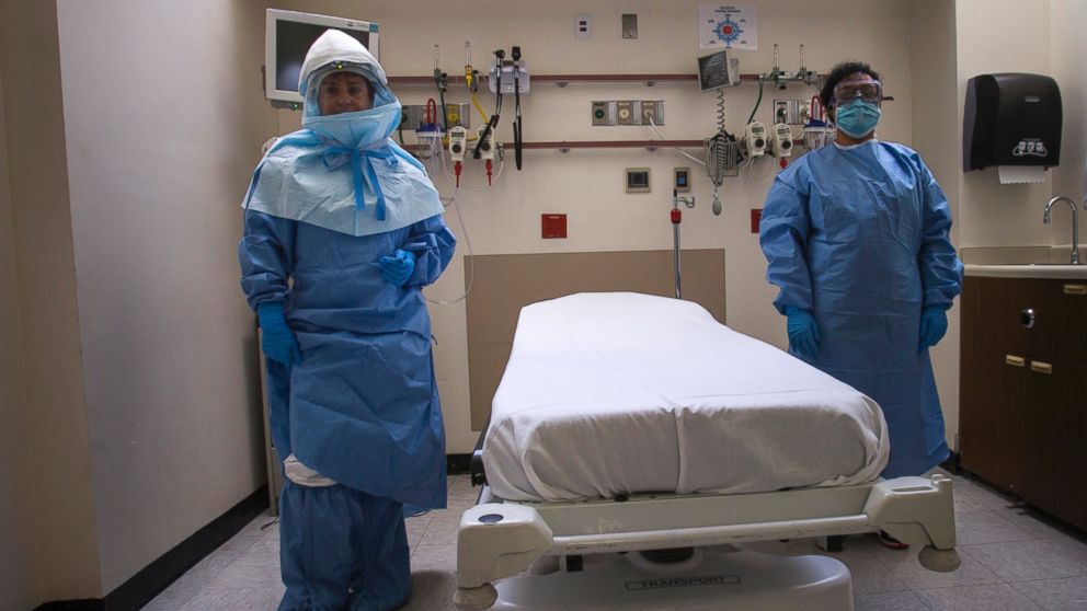 Health care workers display protective gear, which hospital staff would wear to protect them from an Ebola virus infection, inside an isolation room as part of a media tour of the emergency department of Bellevue Hospital in New York City, Oct. 8, 2014.   