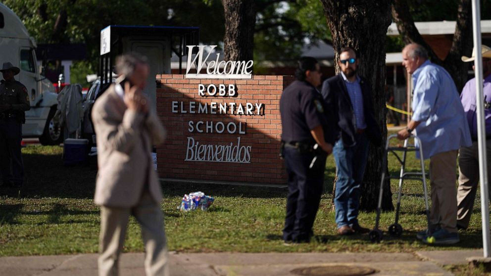 PHOTO: People stand outside Robb Elementary School in Uvalde, Texas, May 25, 2022. 
