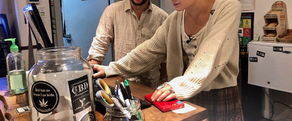 In this photo taken Sept. 20, 2019, David Alport, owner of the Bridge City Collective marijuana dispensary in Portland, Ore., goes over sales numbers with the stores general manager Cameron Moore. The company has seen a 31% decrease in its sales of