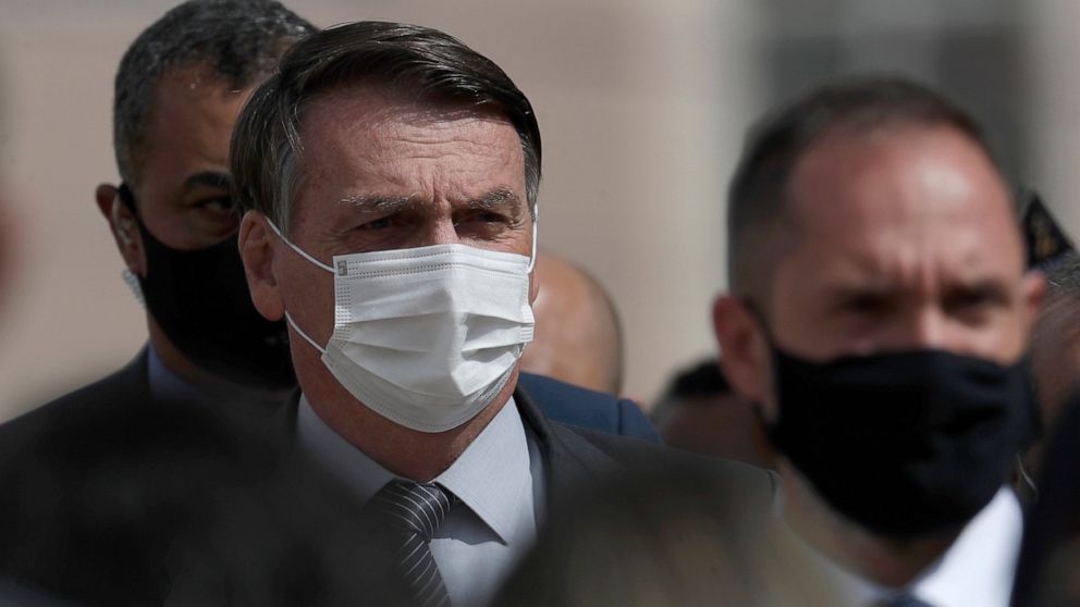Wearing a mask to curb the spread of the new coronavirus, Brazil's President Jair Bolsonaro arrives for a ceremony to deliver affordable homes built by the government, in a neighborhood of Brasilia, Brazil, Monday, Apr. 5, 2021. (AP Photo/Eraldo Peres)