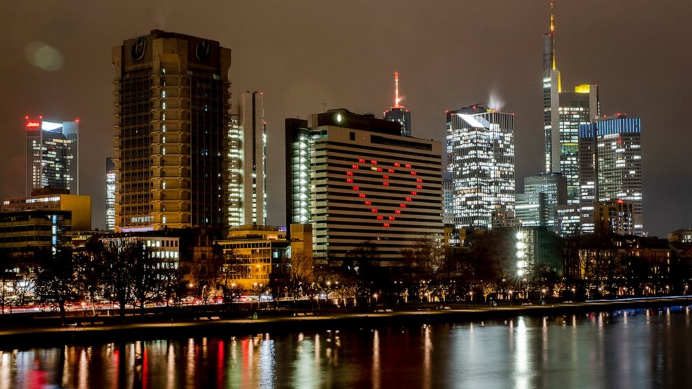 FILE - A hotel has switched on the lights in some rooms to form a heart near the buildings of the banking district in in Frankfurt, Germany, Dec. 10, 2020, as the German government discusses further restrictions to avoid the outspread of the coronavi