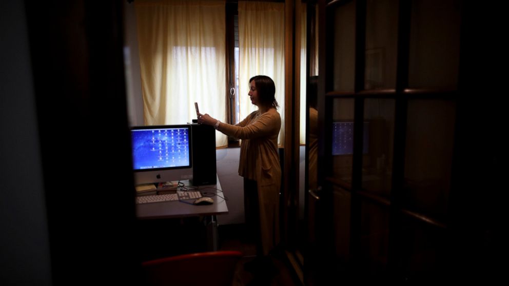 Psychologist Maria Clara Benitez text messages in the room where she attends patients online at her home during a government-ordered lockdown to curb the spread of the new coronavirus in Buenos Aires, Argentina, Monday, July 20, 2020. In the age of c