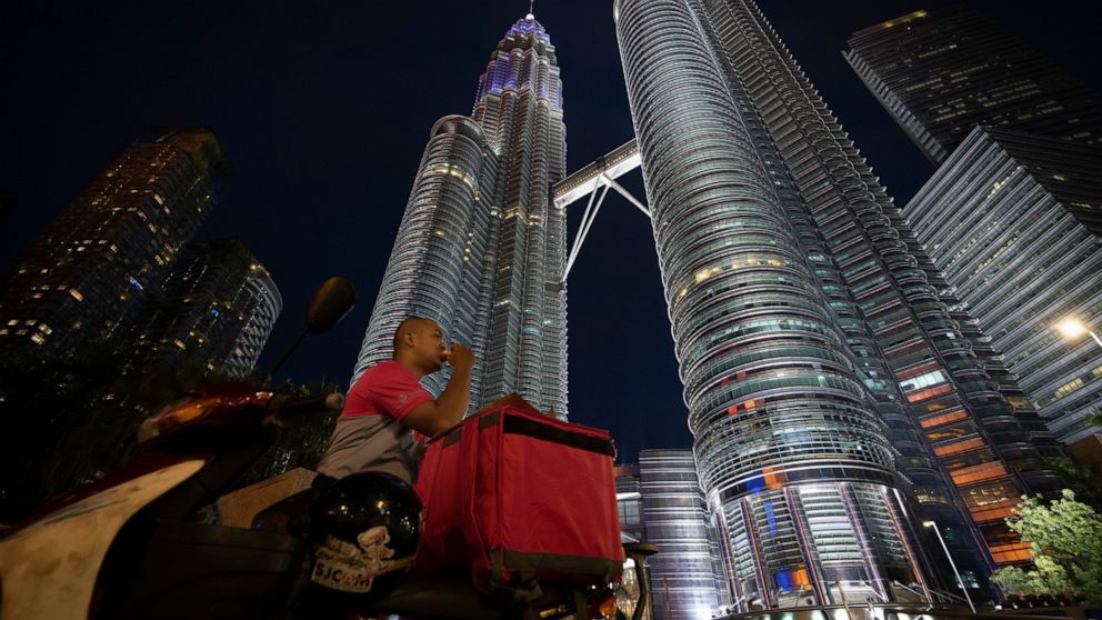 Food delivery riders break their fast in front of Twin Towers during the movement control order due to the outbreak of the coronavirus disease (COVID-19) in Kuala Lumpur, Malaysia, on Friday, May 1, 2020. Malaysia will allow most business activities 