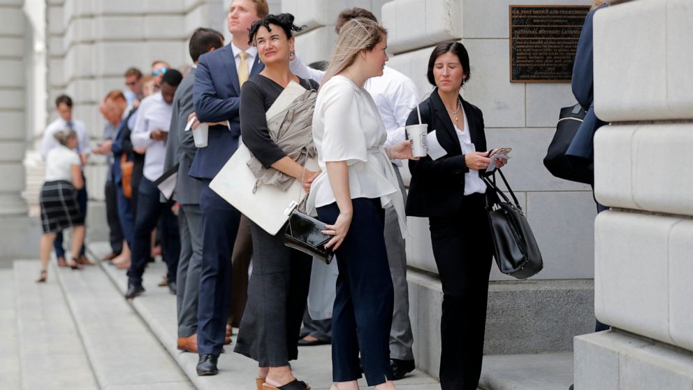 People wait in line to enter the 5th Circuit Court of Appeals to sit in overflow rooms to hear arguments in New Orleans, Tuesday, July 9, 2019. The appeals court will hear arguments today on whether Congress effectively invalidated former President B