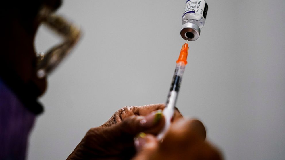 FILE - A syringe is prepared with the Pfizer COVID-19 vaccine at a vaccination clinic at the Keystone First Wellness Center in Chester, Pa., Dec. 15, 2021. Pfizer says tweaking its COVID-19 vaccine to better target the omicron variant is safe and boo