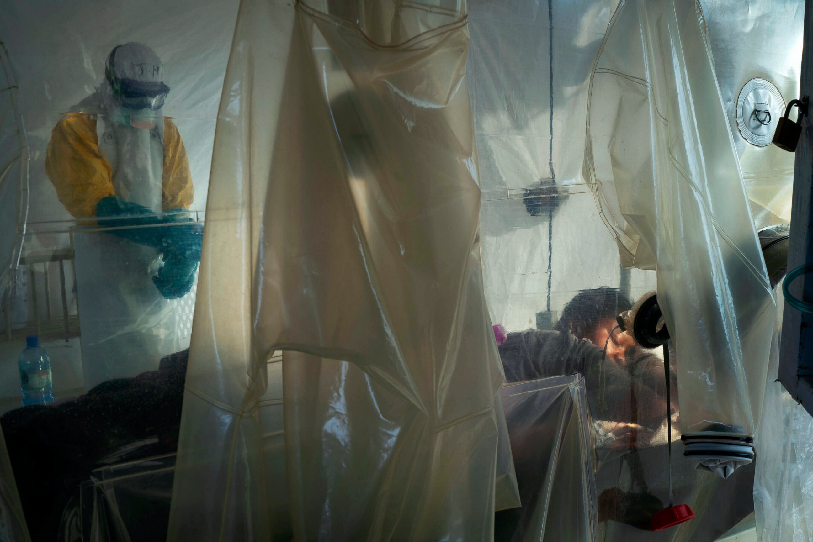PHOTO: FILE - In this July 13, 2019 file photo, health workers wearing protective gear check on a patient isolated in a plastic cube at an Ebola treatment center in Beni, Congo.
