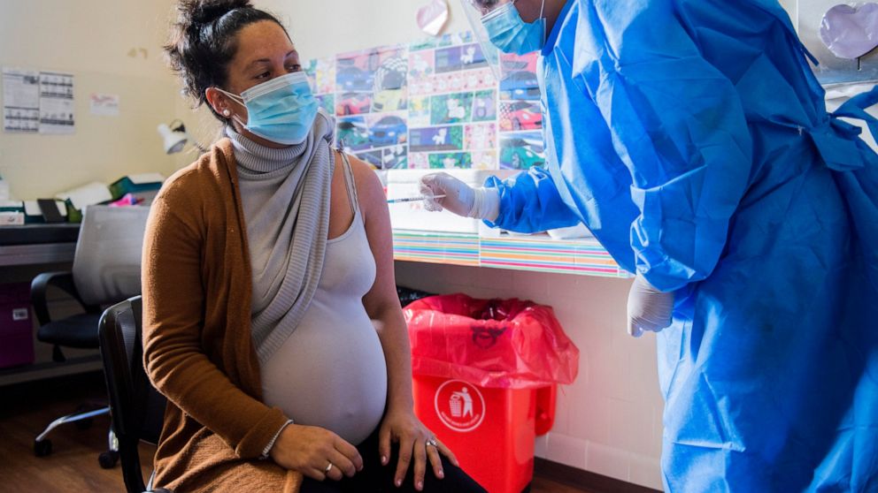 FILE - In this Wednesday, June 9, 2021 file photo, A nurse gives a shot of the Pfizer vaccine for COVID-19 to a pregnant woman in Montevideo, Uruguay. Two obstetricians’ groups are now recommending COVID-19 shots for all pregnant women, citing concer