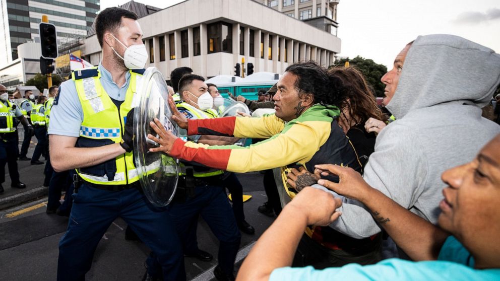 Un manifestant conduit la police néo-zélandaise alors que le cordon se resserre