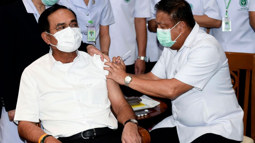 A health worker administers second dose of the AstraZeneca COVID-19 vaccine to Thailand's Prime Minister Prayuth Chan-ocha, left, at Bamrasnaradura Infectious Diseases Institute in Bangkok, Thailand, Monday, May 24, 2021. (Government Spokesman Office