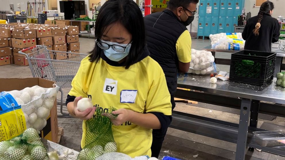 A volunteer packs onions in the warehouse of the Alameda County Community Food Bank in Oakland, Calif., on Nov. 5, 2021. U.S. food banks dealing with increased demand from families sidelined by the pandemic now face a new challenge – surging food pri