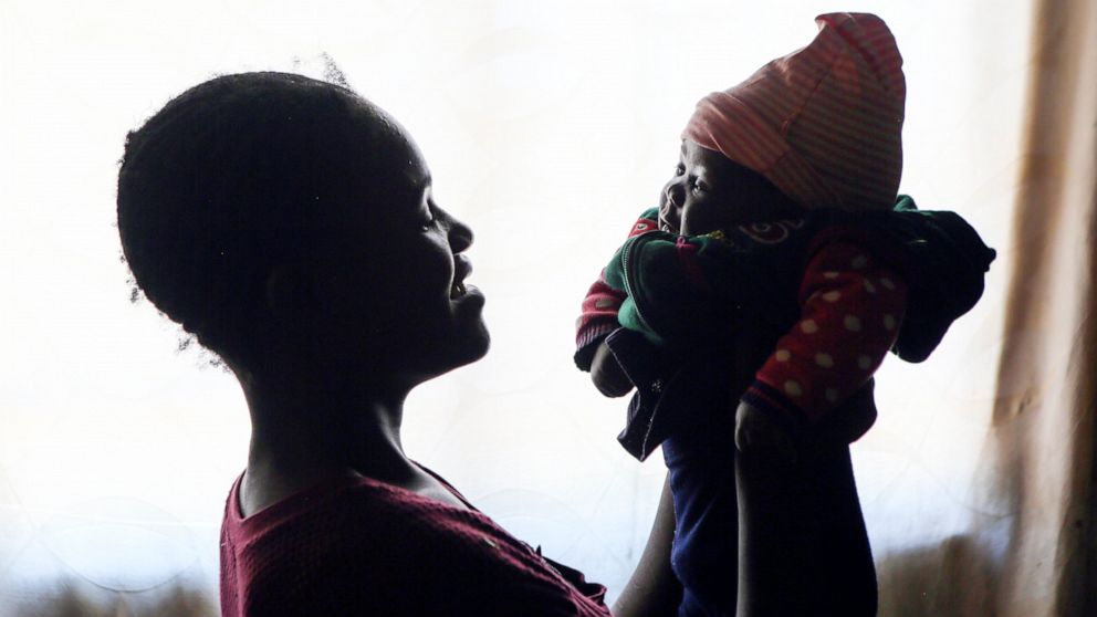 Virginia Mavhunga, a 13-year-old teenage mother, plays with her child at her rural home in Murehwa, 80 kilometres (50 miles) northeast of Zimbabwe's capital Harare, Friday, Dec. 10, 2021. Virginia dropped out of school after falling pregnant and beca