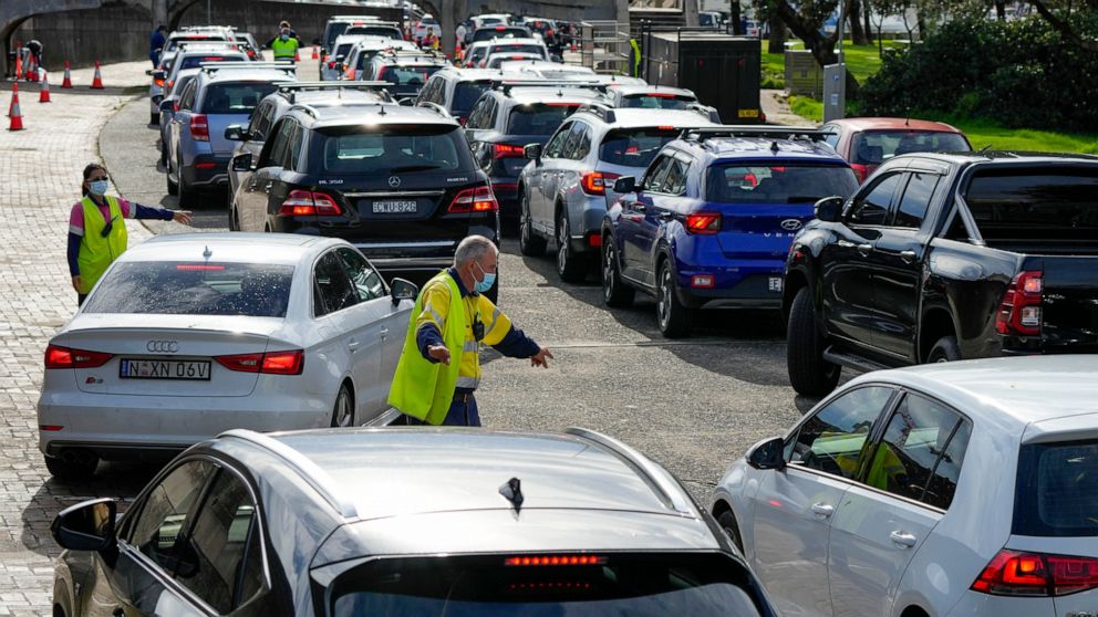 FILE - Traffic marshalls direct cars at a drive-through COVID-19 testing clinic at Bondi Beach in Sydney, Australia, on Jan. 8, 2022. Australia’s most populous state, New South Wales, made the reporting of rapid antigen test results mandatory Wednesd