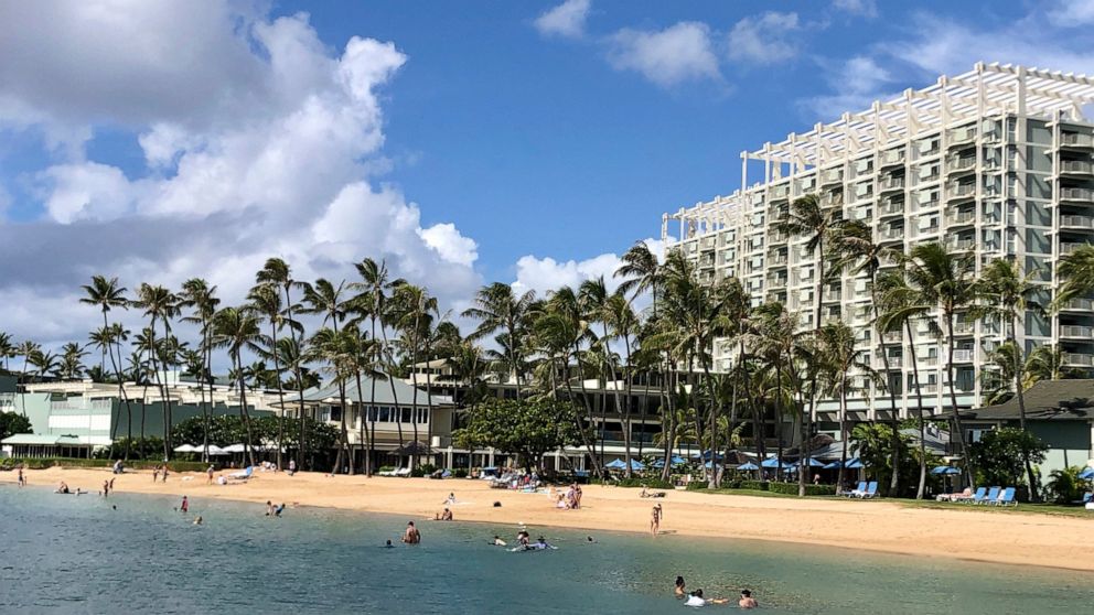 FILE - In this Sunday, Nov. 15, 2020, file photo, people are seen on the beach and in the water in front of the Kahala Hotel & Resort in Honolulu. As Hawaii struggles to control COVID-19 as the highly contagious delta variant spreads, Gov. David Ige 